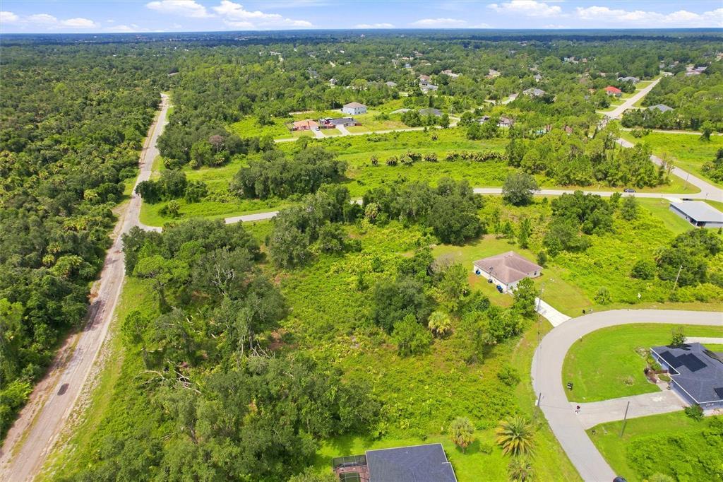 An aerial view shows a residential lot with scattered trees and houses in a rural area — NYBERG ROAD, NORTH PORT, FL