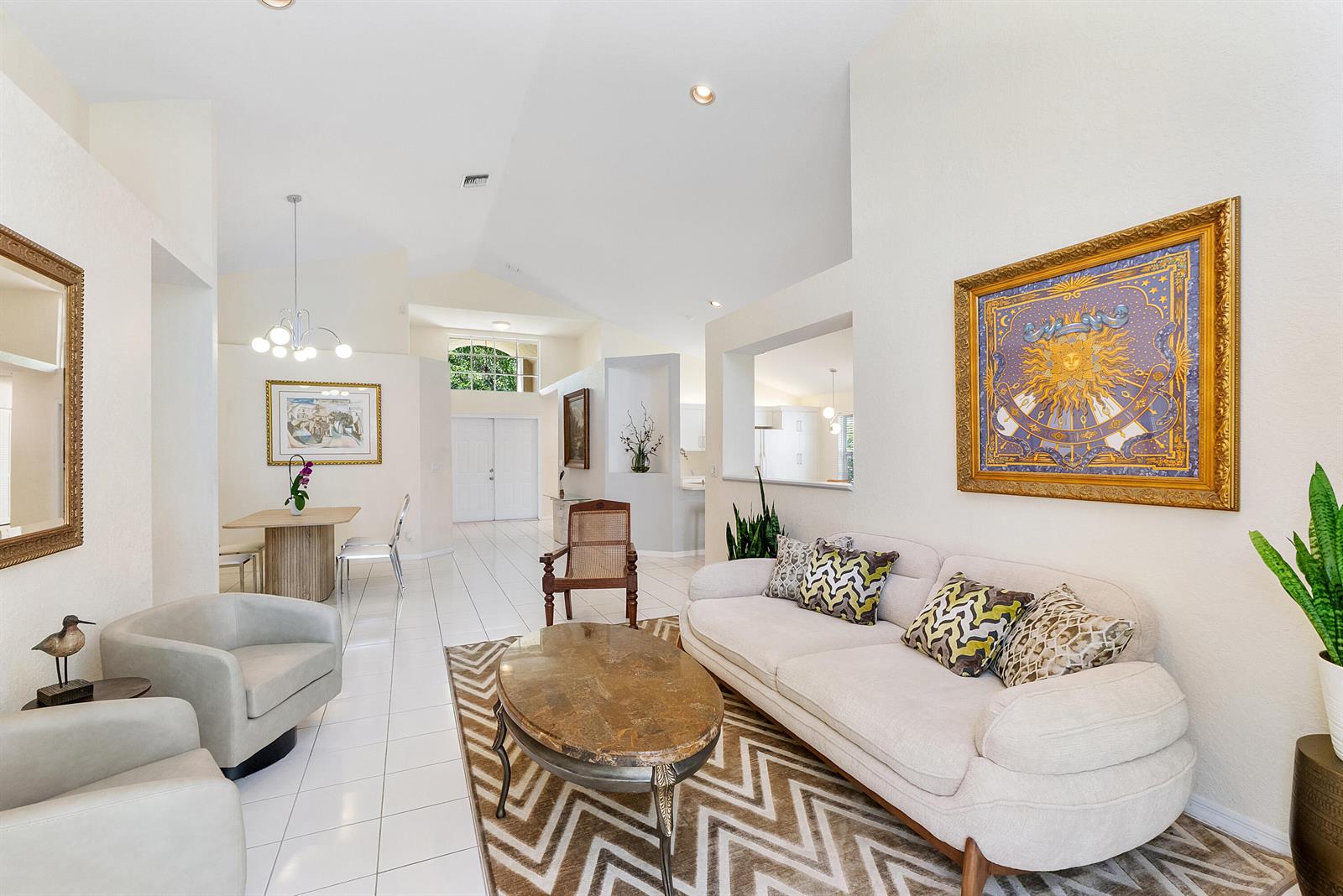 A bright living room features white tile floors, a vaulted ceiling, and a patterned area rug — 2016 Island Circle, Weston FL 33326, WESTON, FL