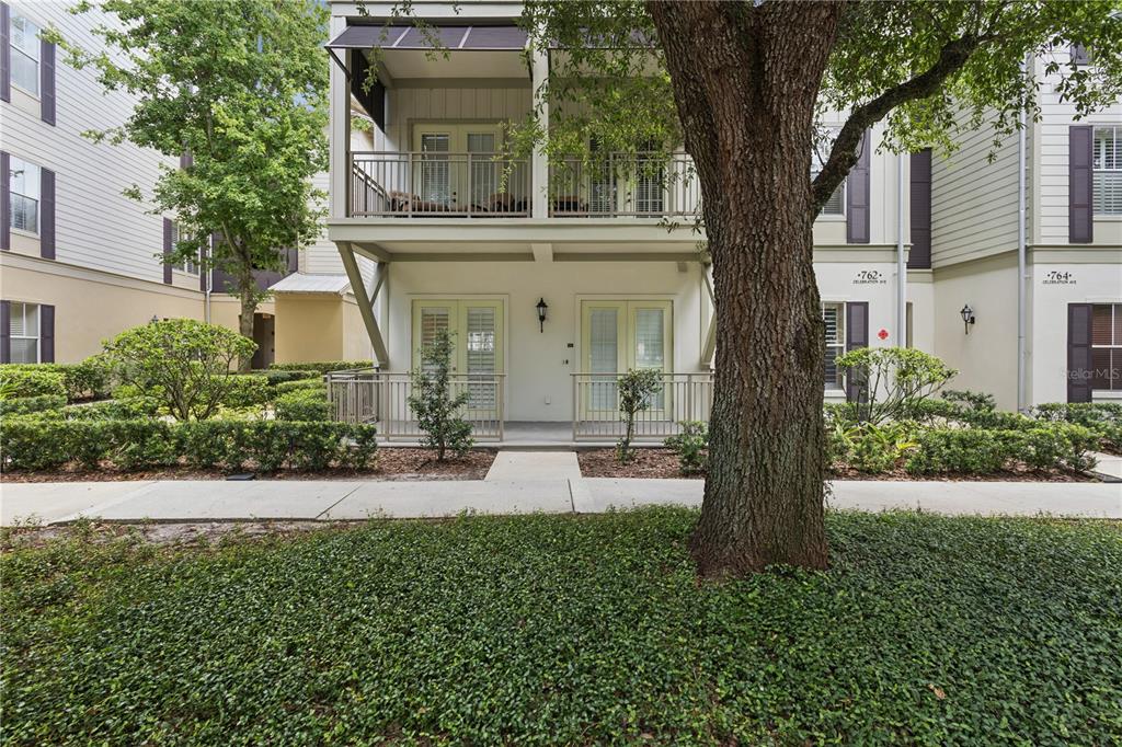 A two-story residential building features a ground-level patio and an upper-level balcony with railings — 762 CELEBRATION AVENUE UNIT 2201, CELEBRATION, FL