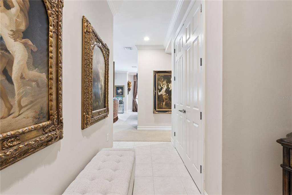A hallway features tiled floors, a tufted bench, and framed artwork on the walls — 762 CELEBRATION AVENUE UNIT 2201, CELEBRATION, FL