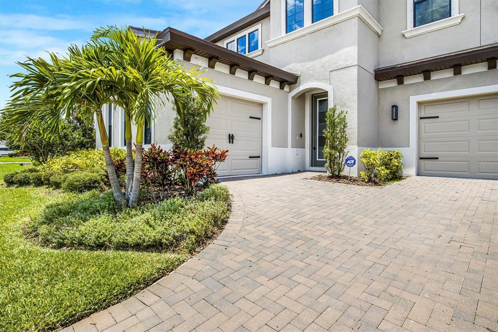 A paved driveway leads to the two-car garage and front entrance of a suburban home — 12859 SATIN LILY DRIVE, RIVERVIEW, FL