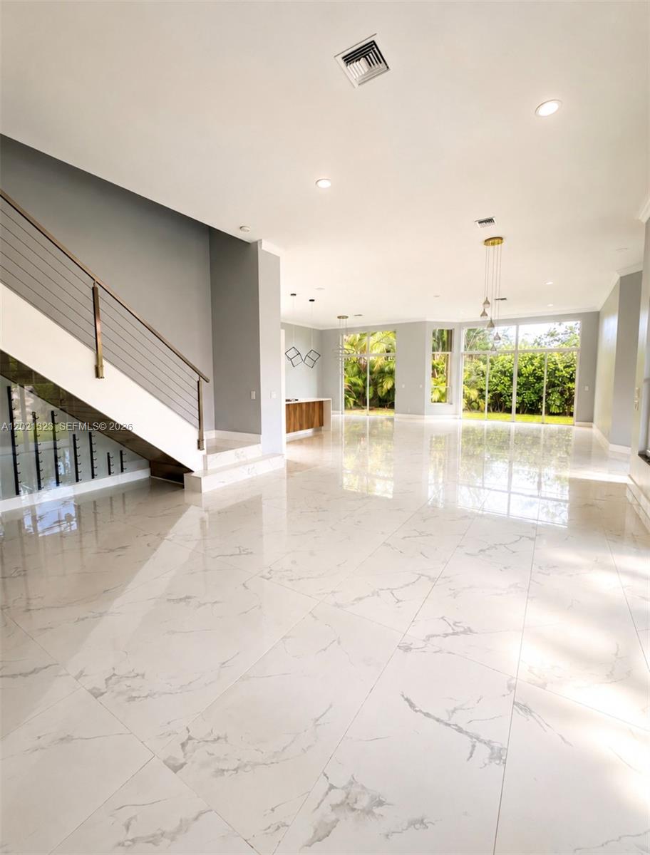 A spacious room features white marble floors, a modern staircase, and large glass sliding doors — 354 Mallard Rd # o, Weston FL 33327, WESTON, FL