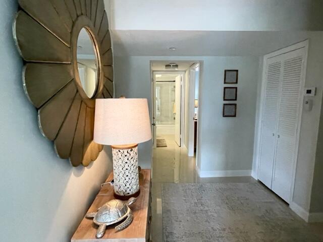 A hallway features a decorative mirror, a table lamp, a turtle figurine, and louvered doors — 500 Ocean Trail Way # 204, Jupiter FL 33477, JUPITER, FL