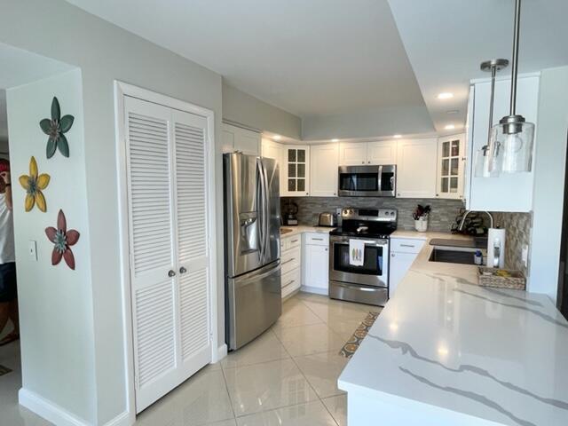 A modern kitchen features white cabinets, stainless steel appliances, and a white quartz countertop — 500 Ocean Trail Way # 204, Jupiter FL 33477, JUPITER, FL