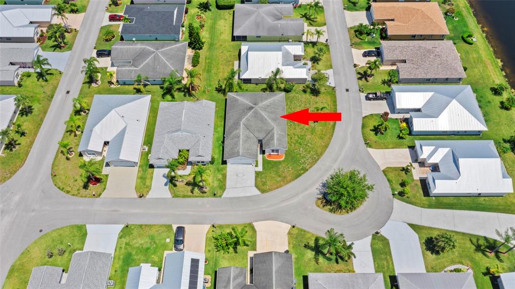 An aerial view shows a residential neighborhood with a red arrow pointing to a house — 6527 ALHELI, FORT PIERCE, FL
