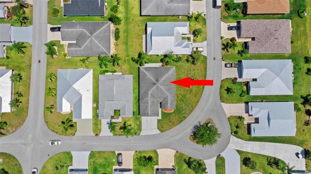 An aerial view shows a residential house with a gray roof in a suburban neighborhood — 6527 ALHELI, FORT PIERCE, FL