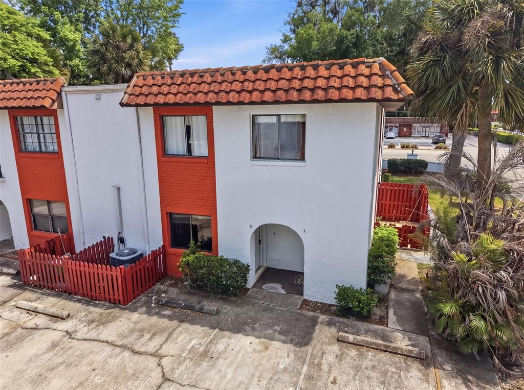 An exterior view of a two-story white and orange townhouse with a red tile roof — 910 BIG TREE ROAD UNIT 202, SOUTH DAYTONA, FL