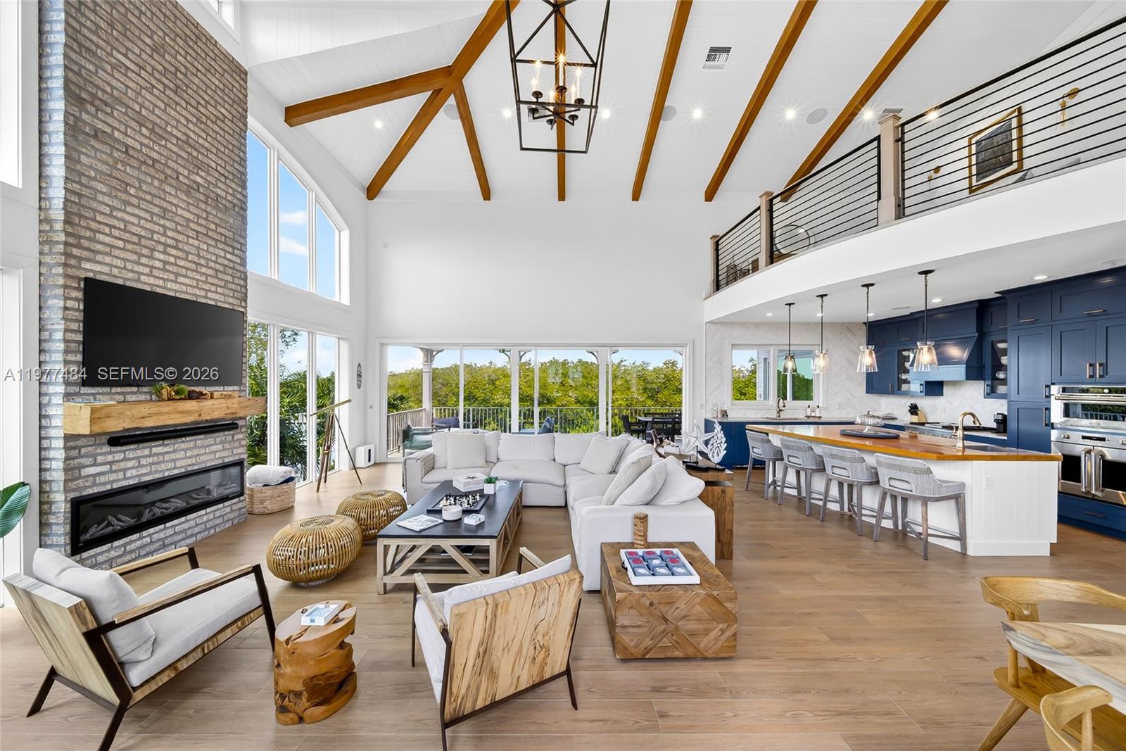 A spacious open-concept living area features a brick fireplace, vaulted ceilings, and a kitchen — 146 Mockingbird Rd, Tavernier FL 33070, TAVERNIER, FL