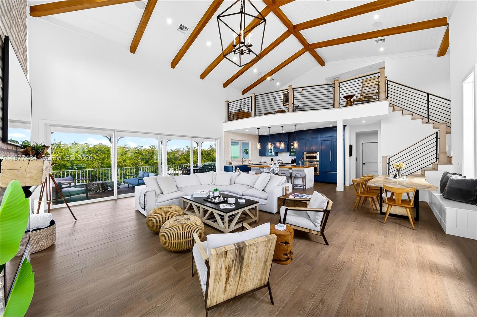 A spacious open-concept living area features vaulted wood-beamed ceilings, a loft, and blue cabinetry — 146 Mockingbird Rd, Tavernier FL 33070, TAVERNIER, FL