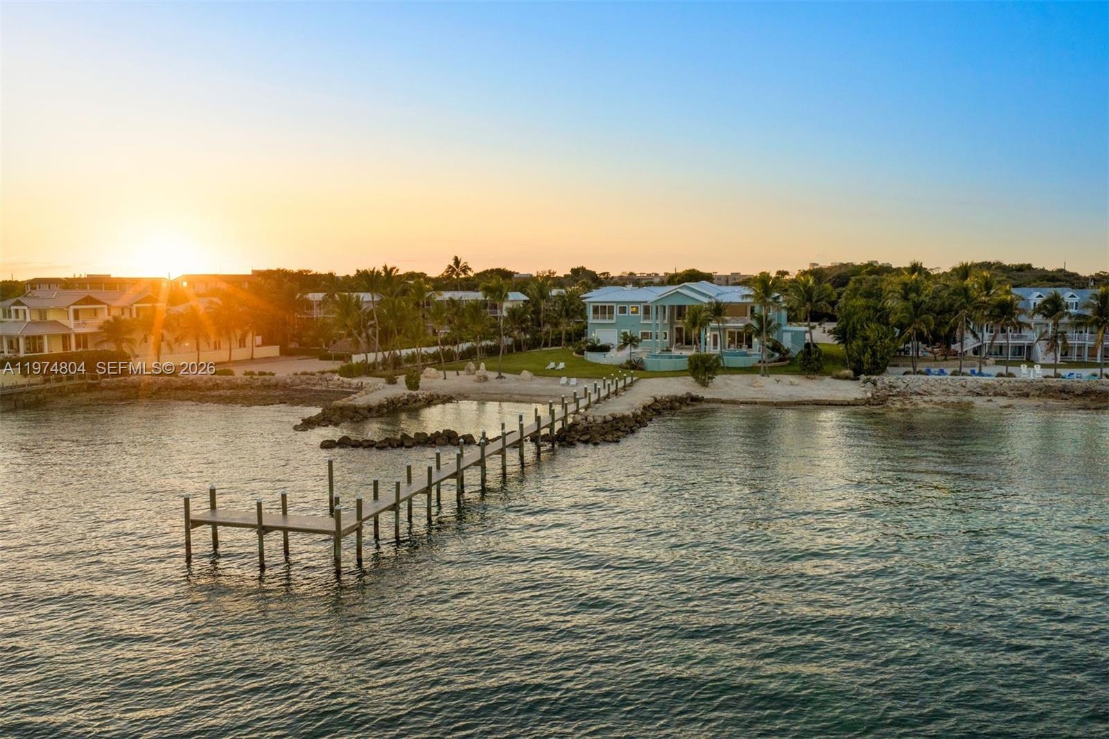 An aerial view shows a waterfront house with a long wooden dock at sunset — 88351 Old Hwy, Islamorada FL 33070, ISLAMORADA, FL
