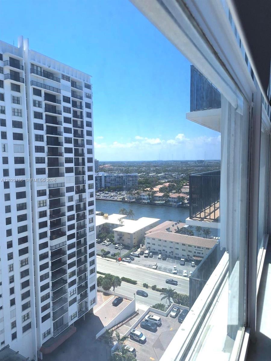 A high-angle view from a window shows a tall apartment building, a canal, and parking lots — 2201 S Ocean Dr # 2001, Hollywood FL 33019, HOLLYWOOD, FL