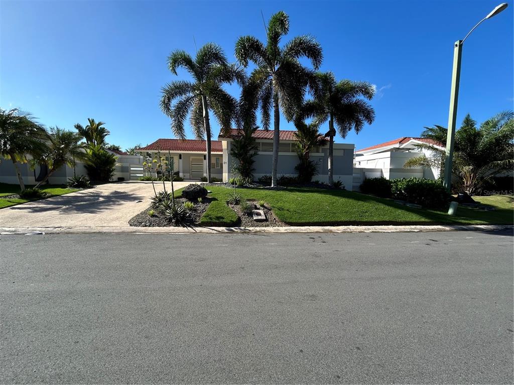 A single-story house with a red tile roof, palm trees, and a paved driveway — 312 SABANERA DORADO, DORADO, PR