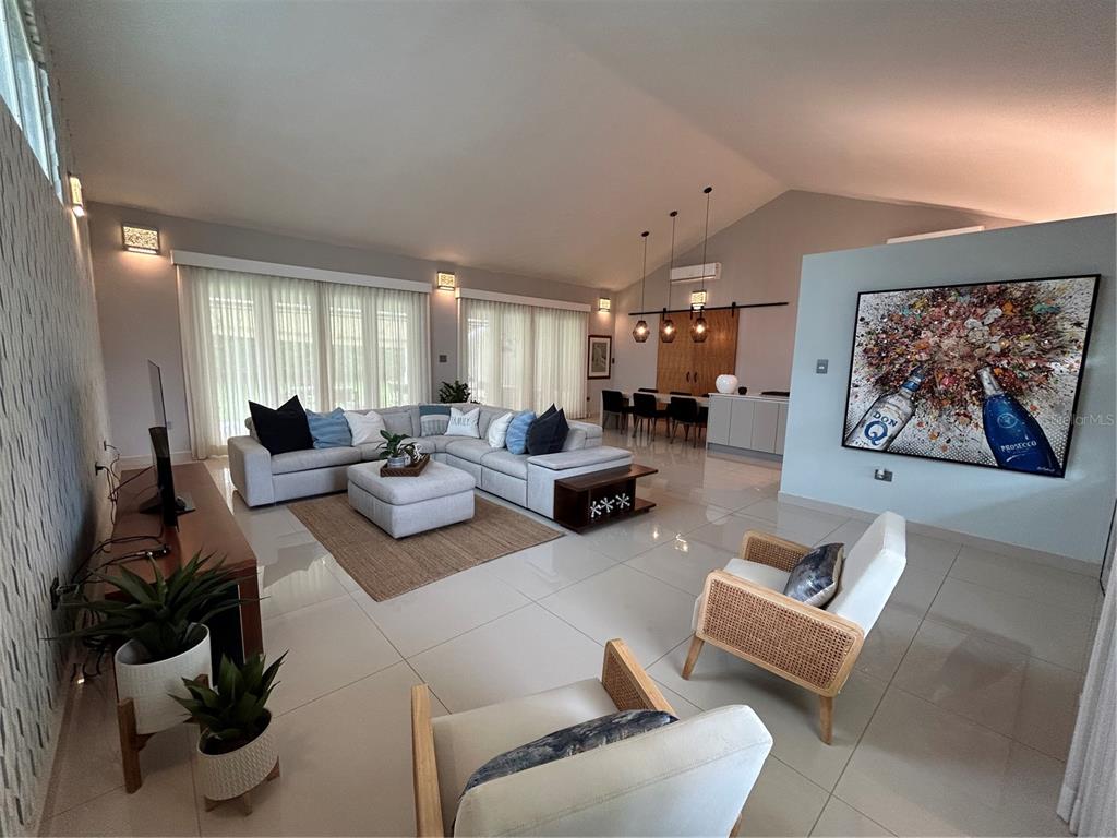 A spacious living room features light tile floors, a sectional sofa, and a large wall painting — 312 SABANERA DORADO, DORADO, PR