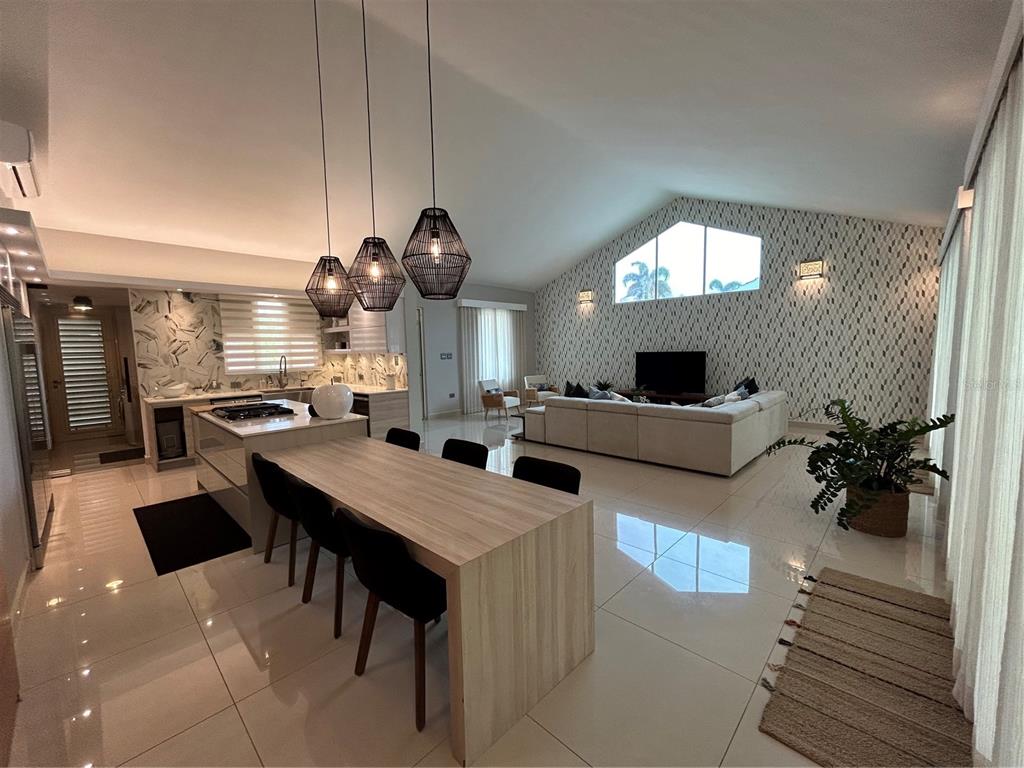 A modern open-concept living room and kitchen with white tile floors and vaulted ceilings — 312 SABANERA DORADO, DORADO, PR