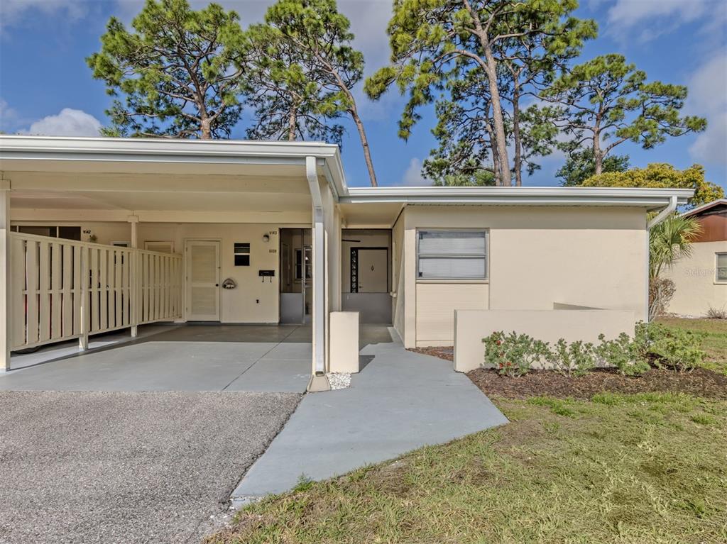 A single-story house features a carport, a concrete walkway, and a small front garden — 6108 GREEN VIEW DRIVE UNIT 143, SARASOTA, FL