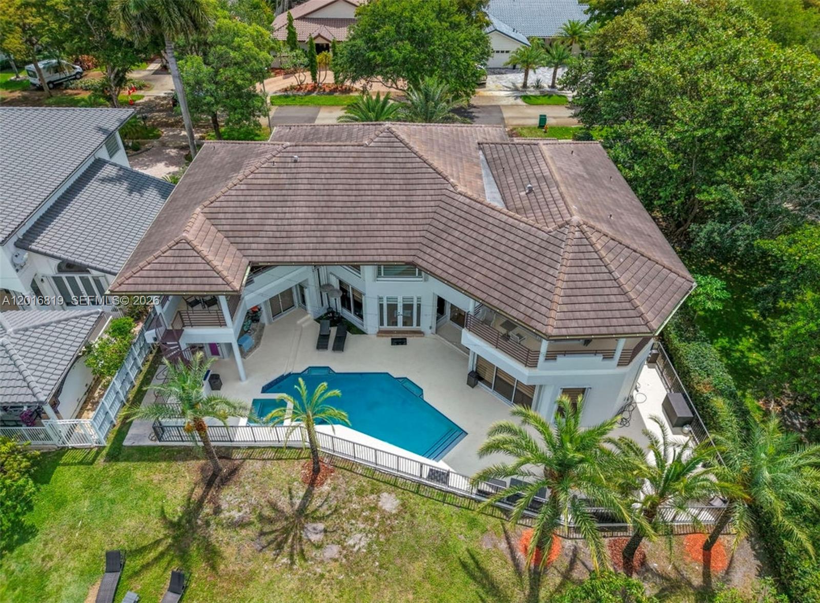 An aerial view of a two-story house with a tiled roof, swimming pool, and palm trees — 14332 Ardoch Pl, Miami Lakes FL 33016, MIAMI LAKES, FL