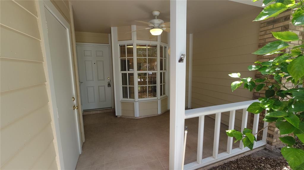 A covered porch features a white front door, a bay window, and a ceiling fan — 6421 REMUS DRIVE, NEW PORT RICHEY, FL