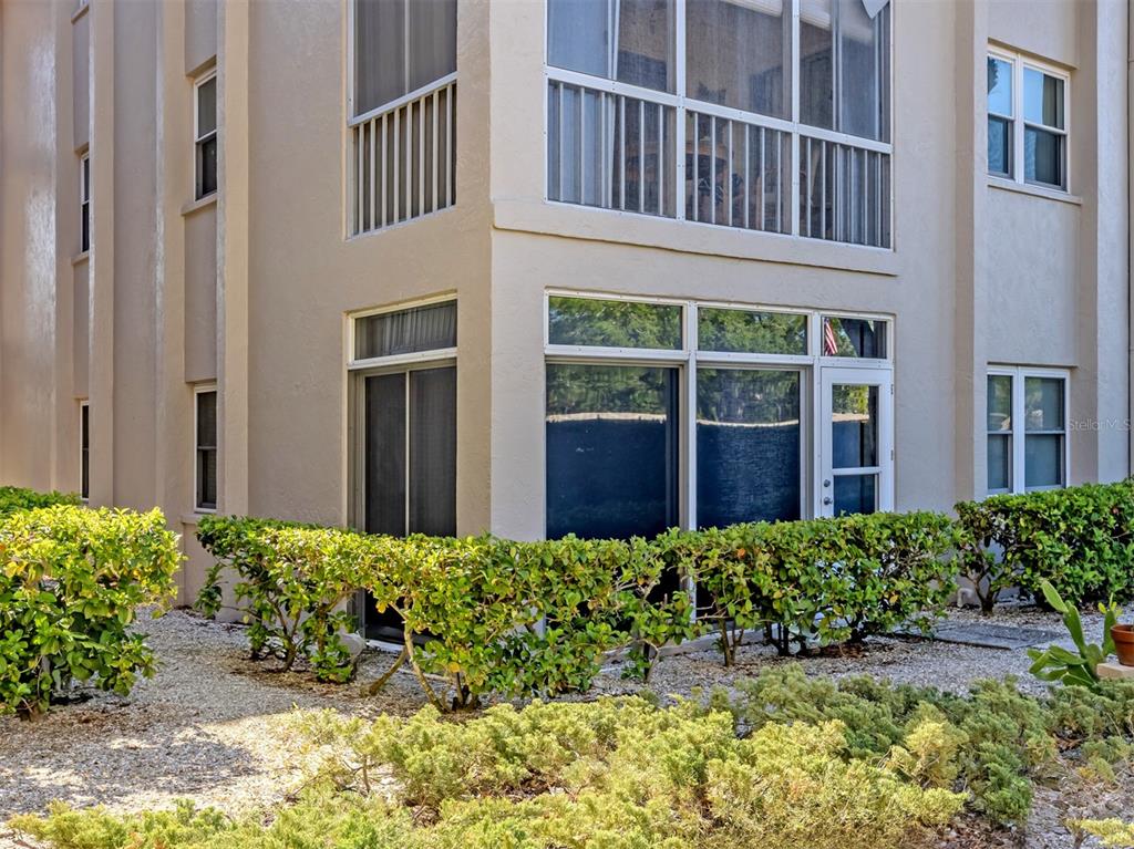 A living and dining room with hardwood floors, wicker furniture, and a ceiling fan — 101 PARK BOULEVARD S UNIT 106, VENICE, FL