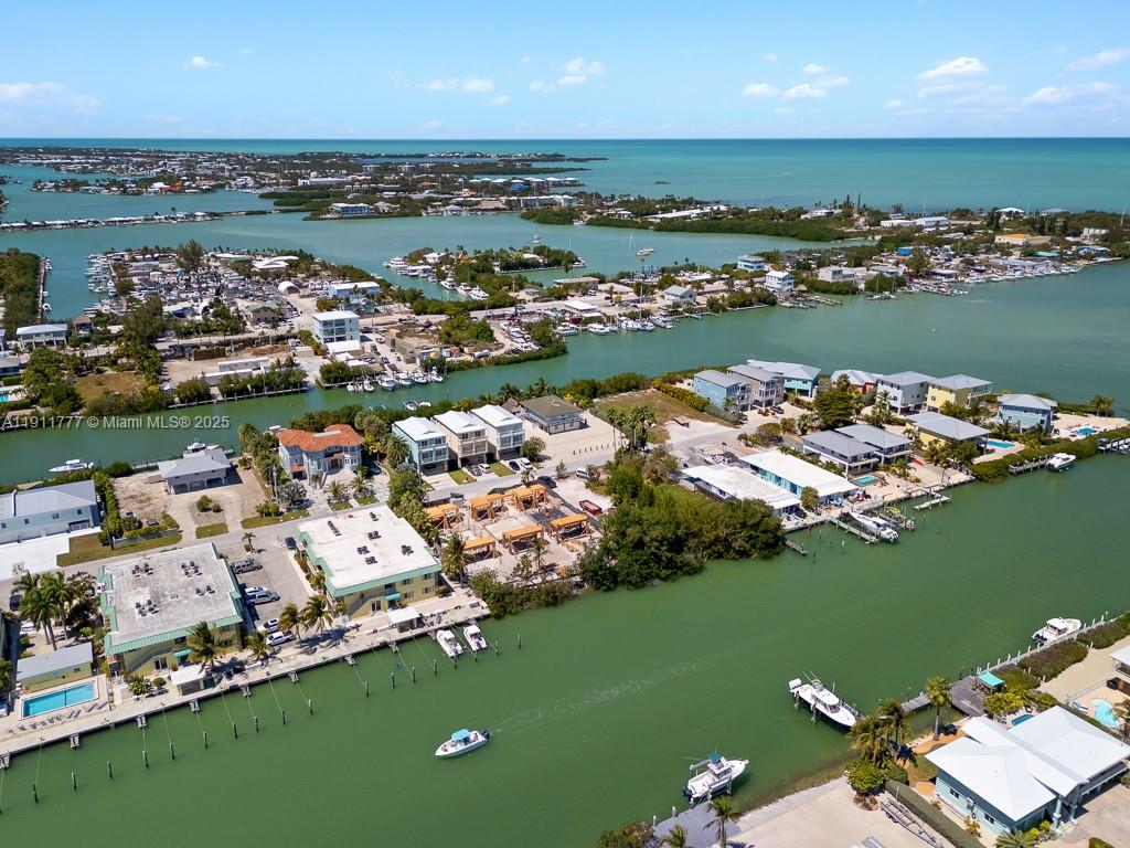 An aerial view shows waterfront homes, boat docks, and canals in a coastal residential area — 112 Avenue D # 1, Marathon FL 33050, MARATHON, FL