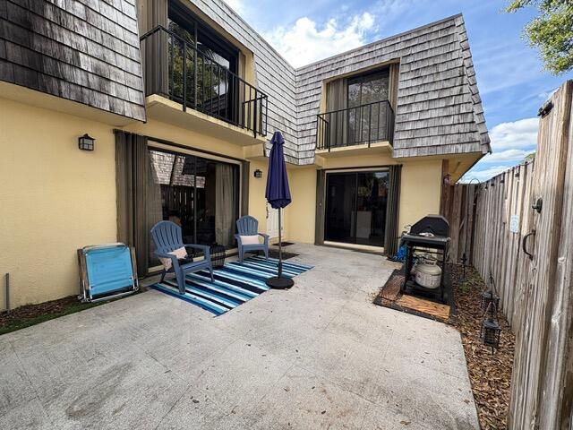 A patio area features two blue chairs on a striped rug and a gas grill — 303 Arabian Road, Palm Springs FL 33461, PALM SPRINGS, FL