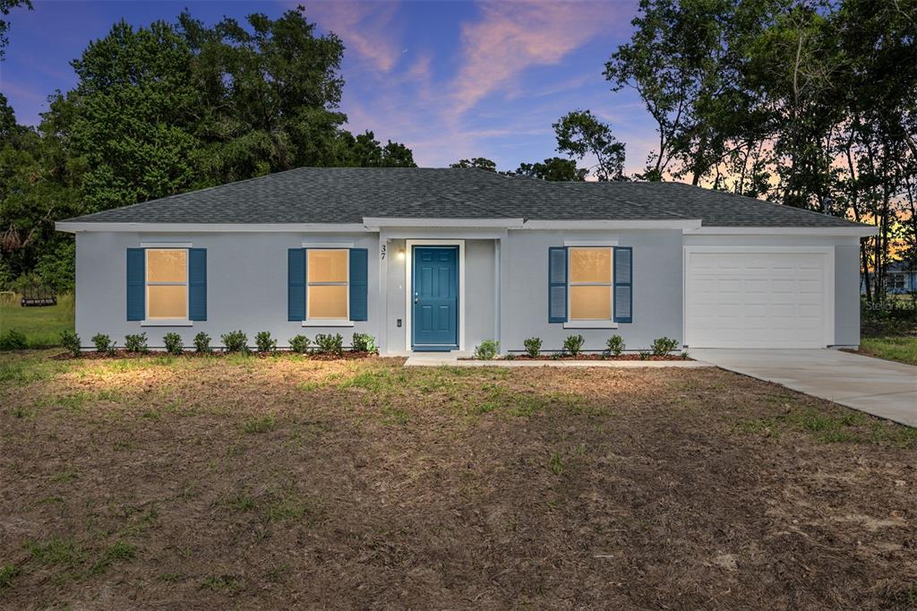 A single-story house with a gray exterior, blue shutters, a blue front door, and garage — 37 DOGWOOD DRIVE PASS, OCALA, FL