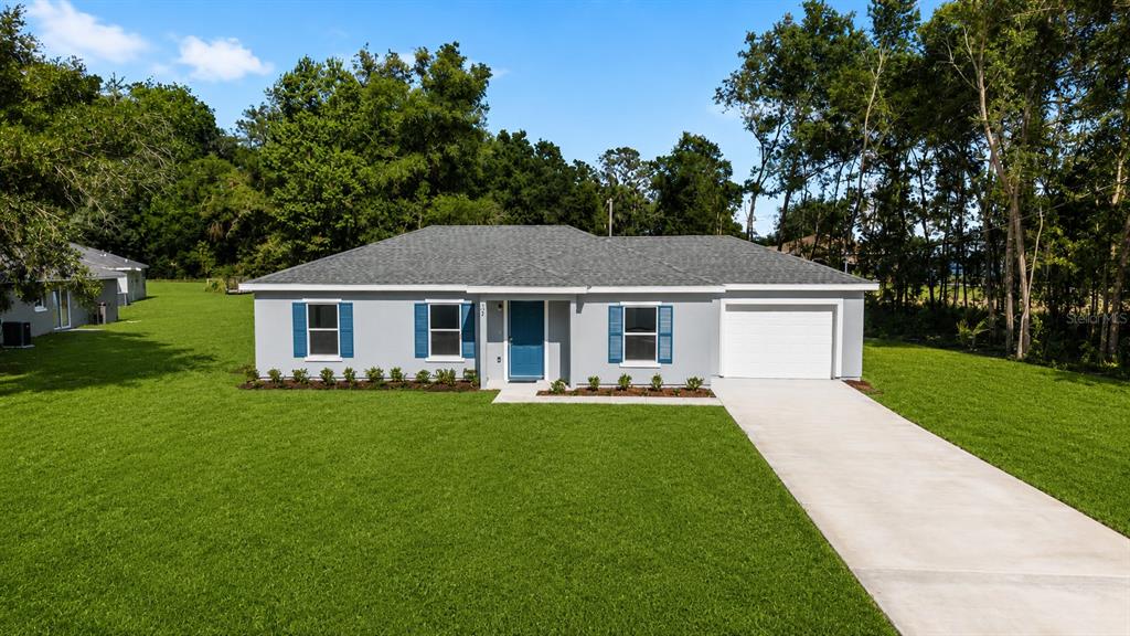 A single-story house with a gray exterior, blue shutters, and a concrete driveway — 37 DOGWOOD DRIVE PASS, OCALA, FL