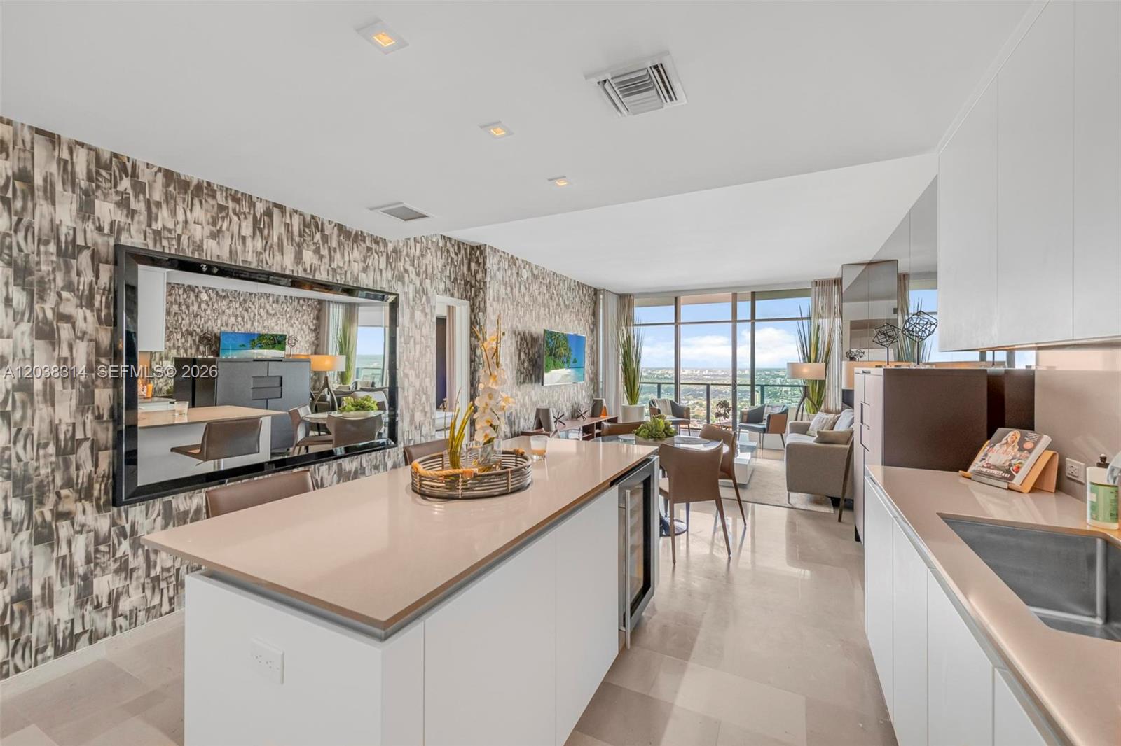 A modern kitchen island with a wine cooler sits in an open-concept living area — 88 SW 7th St # 3806, Miami FL 33130, MIAMI, FL