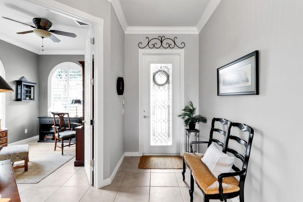 An entryway with a white front door, a black bench, and a view into an office — VERO BEACH, FL