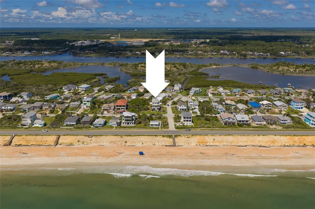 An aerial view shows a beach house marked by a white arrow near the coast — 1955 N CENTRAL AVENUE, FLAGLER BEACH, FL