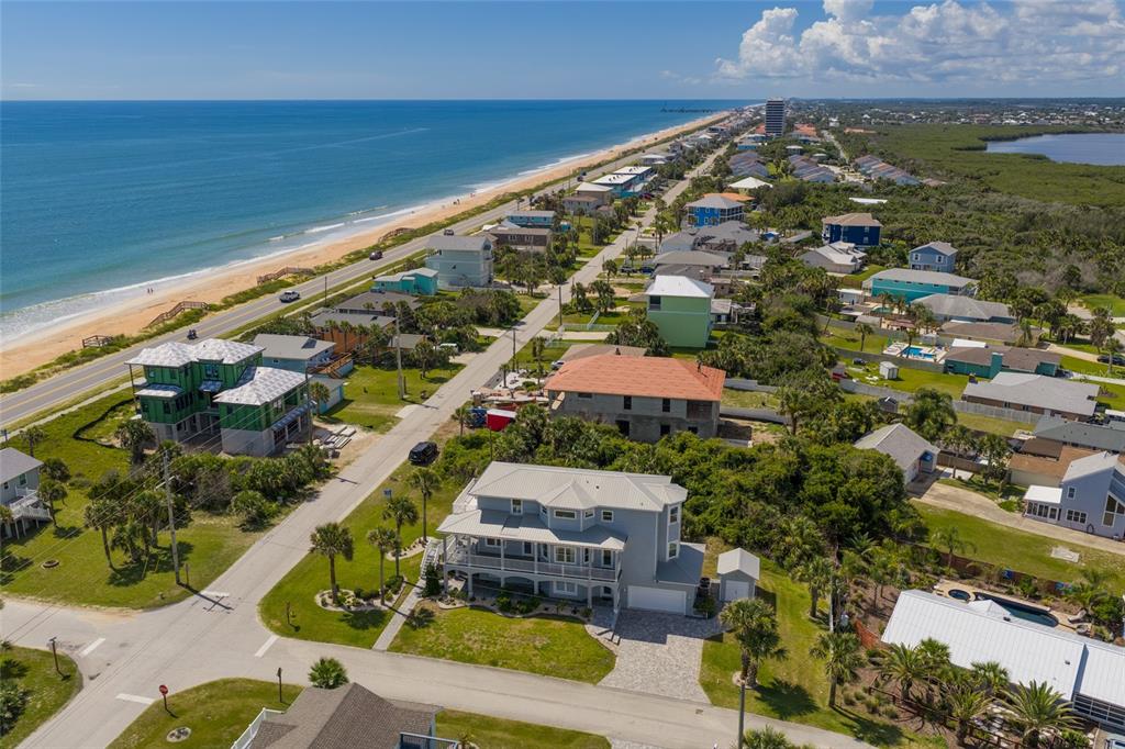 An aerial view shows a coastal neighborhood with houses, a road, and the ocean — 1955 N CENTRAL AVENUE, FLAGLER BEACH, FL
