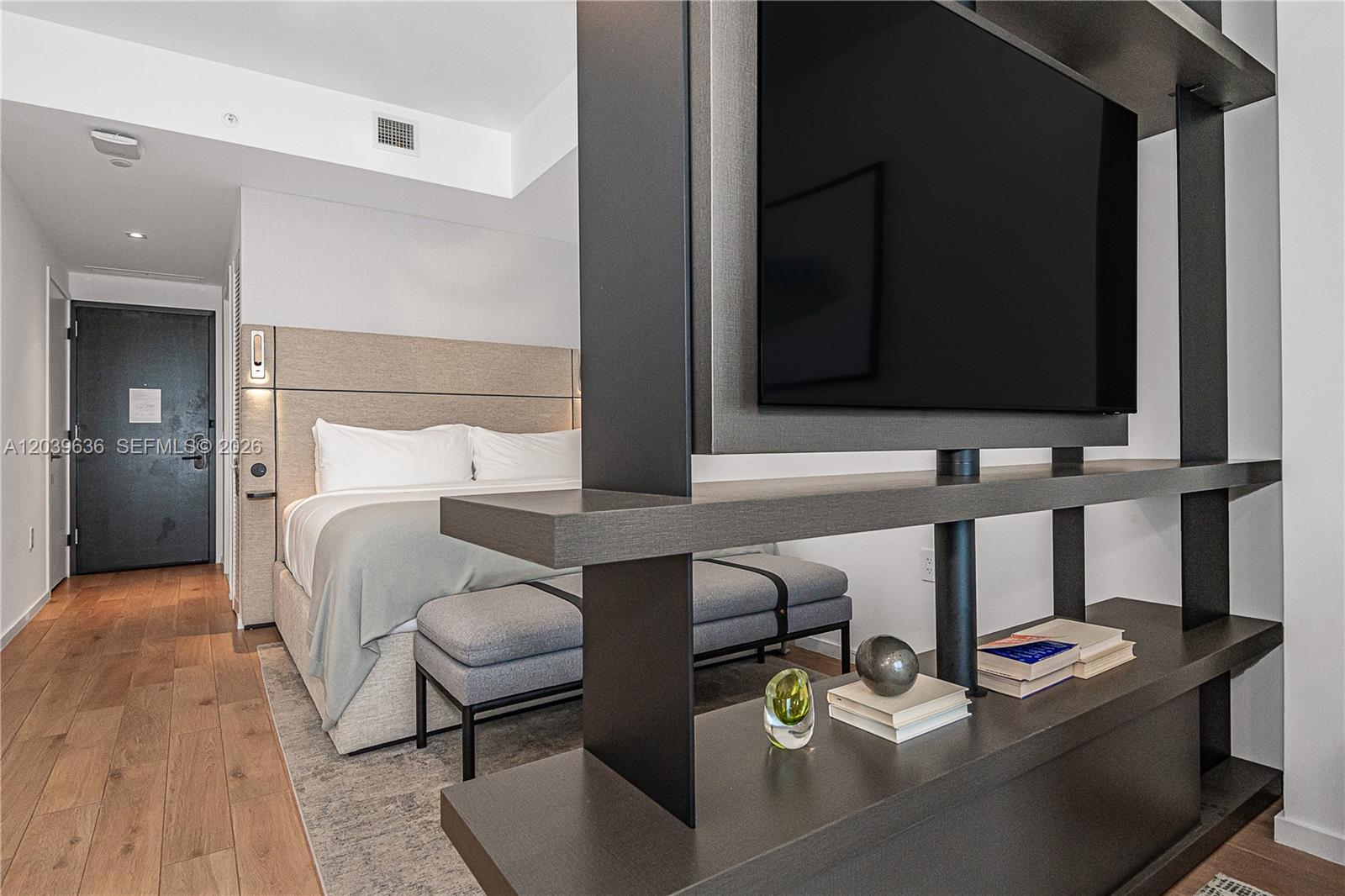 A bedroom features a bed with a headboard and a modern television partition unit — 398 NE 5th St # 2904, Miami FL 33132, MIAMI, FL