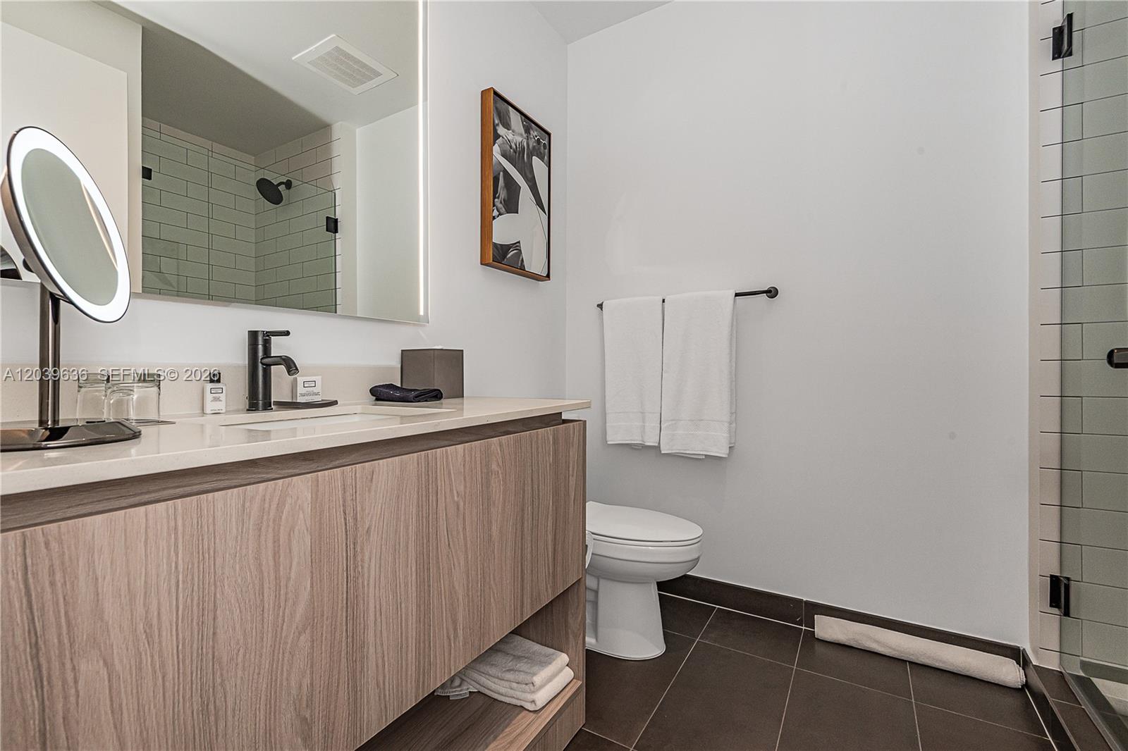 A modern bathroom features a wood-grain vanity, white countertop, and a glass-enclosed shower — 398 NE 5th St # 2904, Miami FL 33132, MIAMI, FL