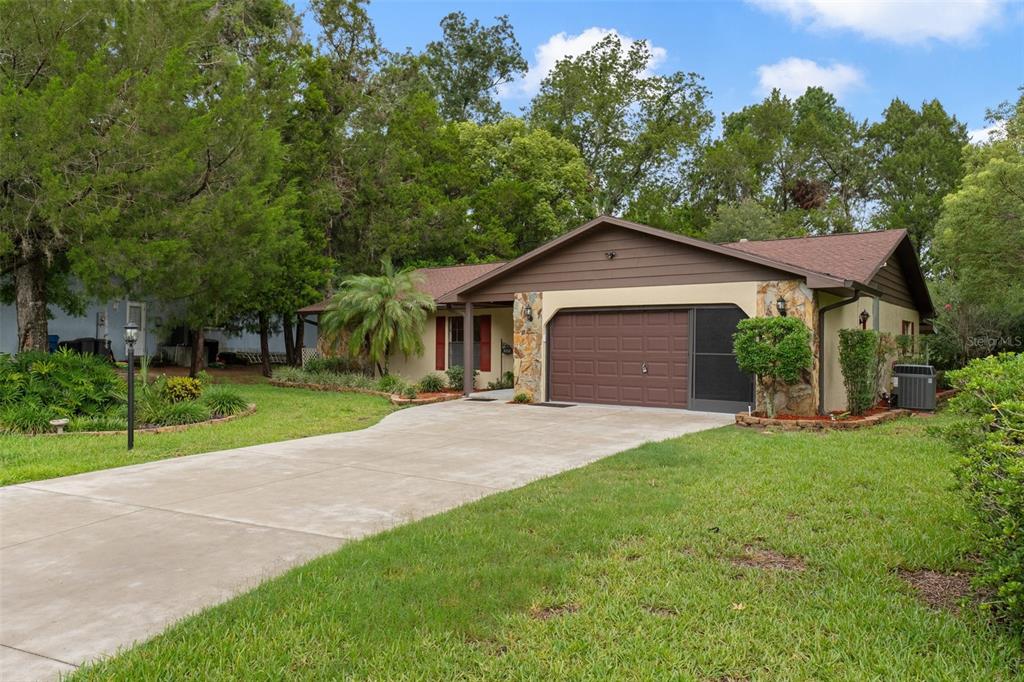 A single-story house with a brown roof, stone accents, and a concrete driveway — 4856 S DRIFTWOOD WAY, HOMOSASSA, FL