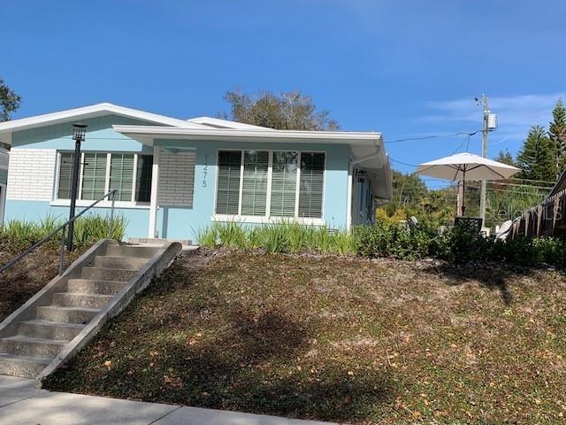 A light blue single-story house with a concrete staircase leading to the front entrance — 1275 WOODDELL DRIVE, SAFETY HARBOR, FL
