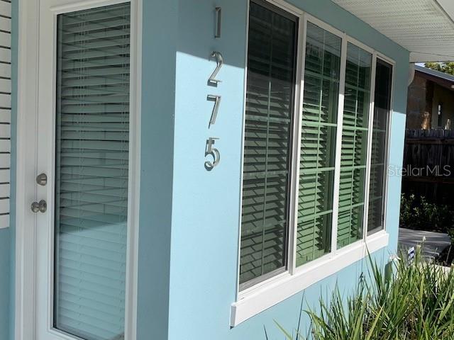 A light blue exterior wall features a glass door and windows with white blinds — 1275 WOODDELL DRIVE, SAFETY HARBOR, FL