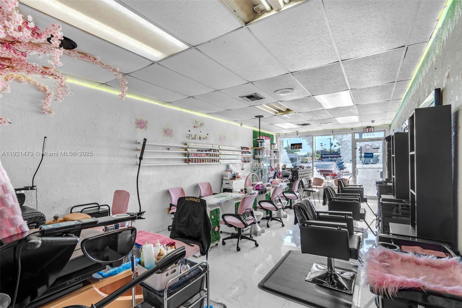 A commercial salon space features nail stations, styling chairs, pink accents, and white tile flooring — 6761 W Flagler St, Miami FL 33144, MIAMI, FL
