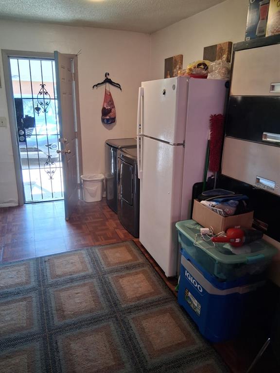 A laundry area features a white refrigerator, a washer, a dryer, and a screen door — 3014 N 48TH STREET, TAMPA, FL