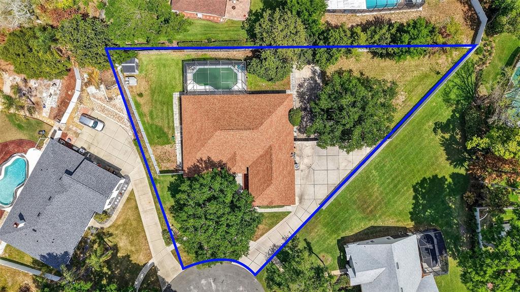 An aerial view shows a house with a pool and large trees on a lot — 11318 SUMMER WIND COURT, CLERMONT, FL