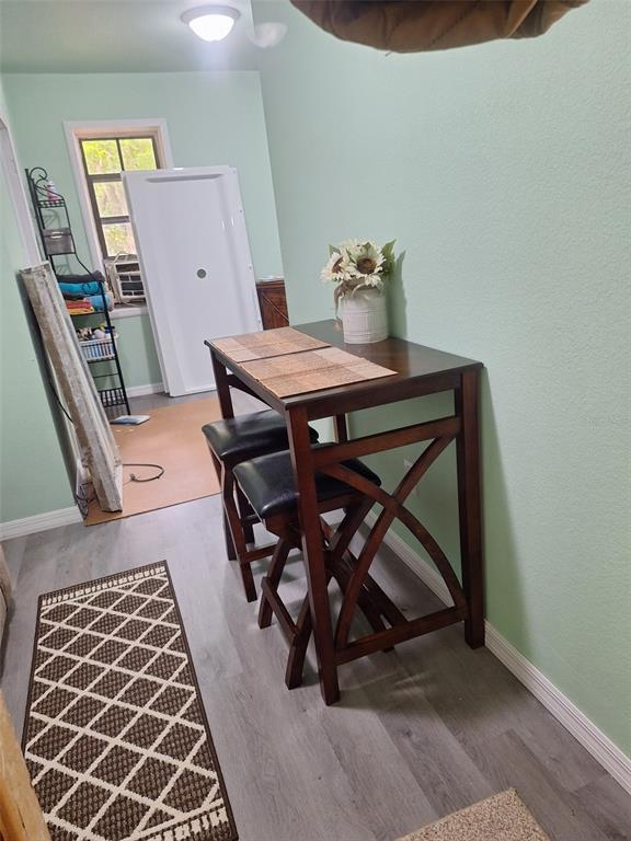 A small dining area features a wooden high-top table with two stools on gray flooring — 11304 ROYAL DRIVE, BROOKSVILLE, FL