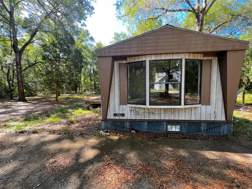 The exterior of a mobile home features a bay window and wood-paneled siding — 1660 S PALM AVENUE, HOMOSASSA, FL