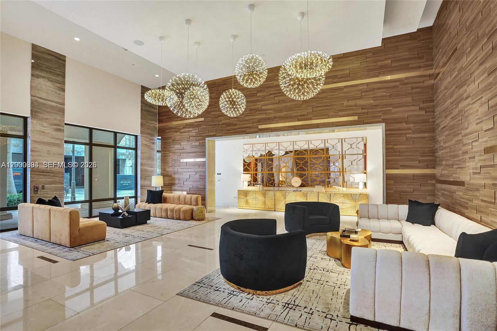 A modern lobby features wood-paneled walls, large spherical pendant lights, and multiple seating areas — 101 E Camino Real # 517, Boca Raton FL 33432, BOCA RATON, FL