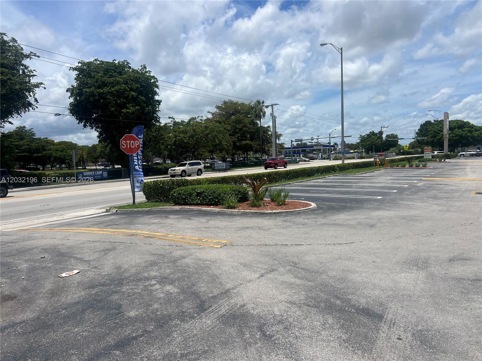 A paved parking lot sits in front of a landscaped median and a public road — SW 107th Ave, Miami FL 33173, MIAMI, FL