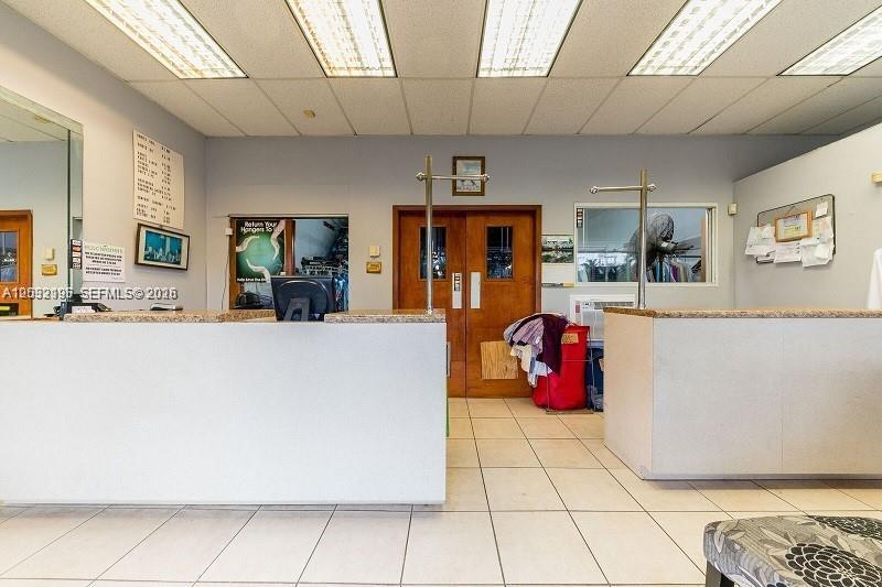 A dry cleaning business interior features a service counter, tiled floors, and wooden double doors — SW 107th Ave, Miami FL 33173, MIAMI, FL