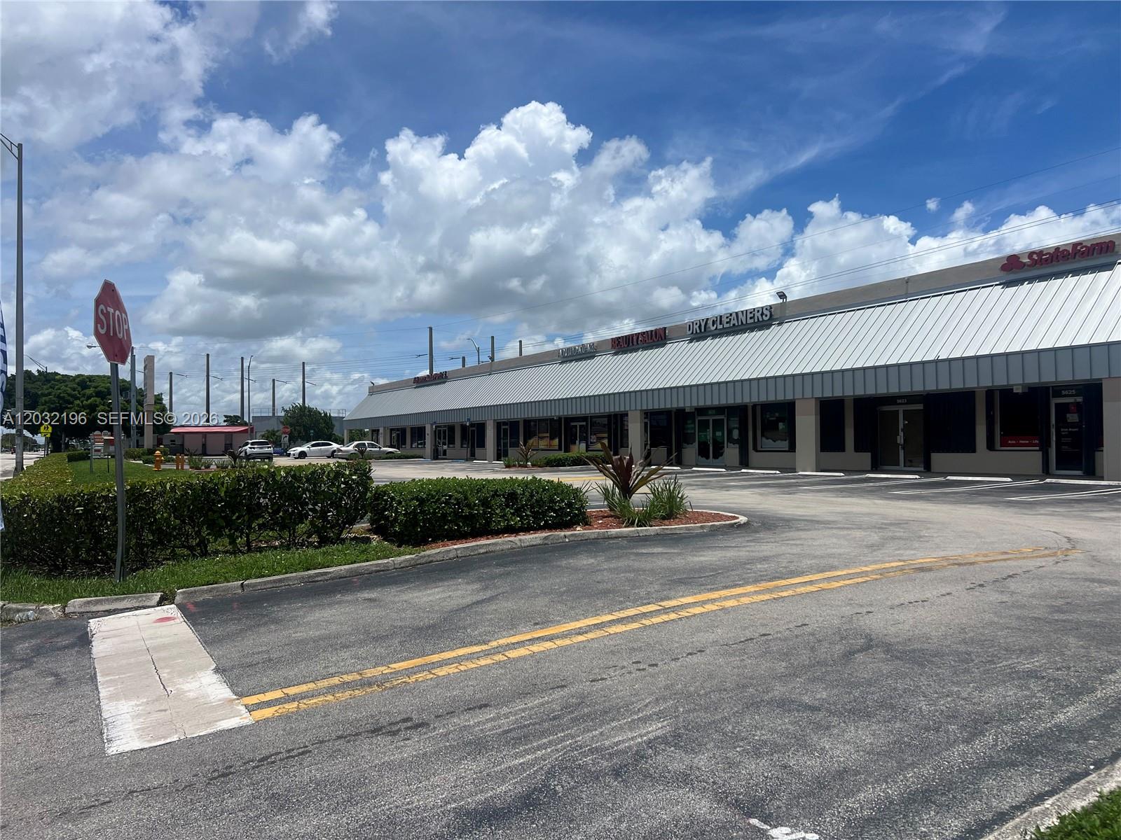 A strip mall with a parking lot, a stop sign, and a blue sky — SW 107th Ave, Miami FL 33173, MIAMI, FL