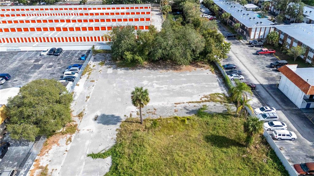 An aerial view shows a vacant paved lot situated between a storage facility and apartments — 4849 S ORANGE BLOSSOM TRAIL, ORLANDO, FL