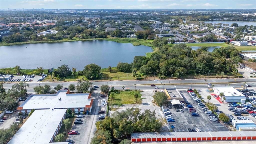 An aerial view shows a commercial property with parking lots, a lake, and a busy road — 4849 S ORANGE BLOSSOM TRAIL, ORLANDO, FL