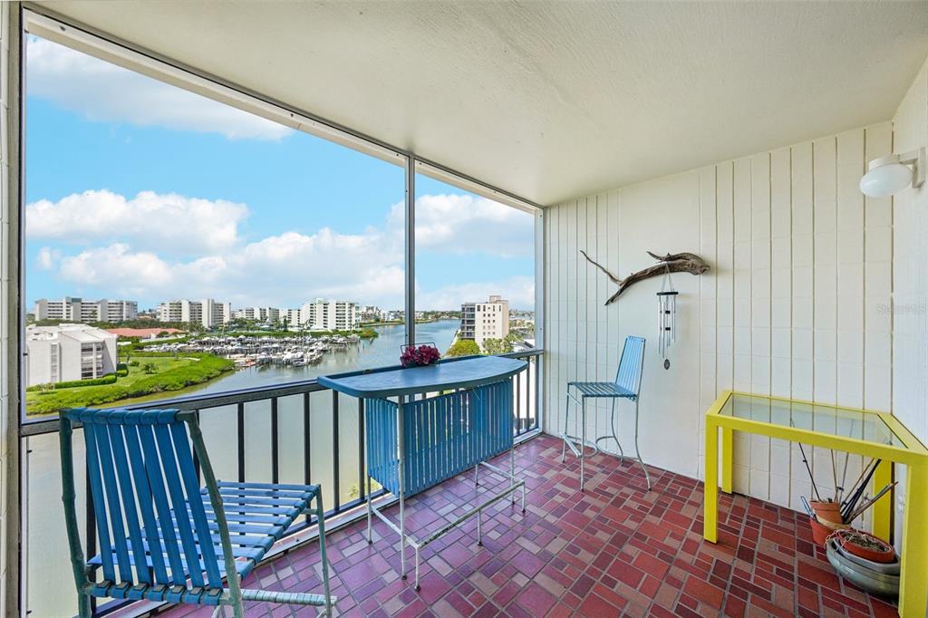 A bright lobby features wicker chairs, a patterned valance, and glass doors leading outside — 7400 SUN ISLAND DRIVE S UNIT 802, SOUTH PASADENA, FL