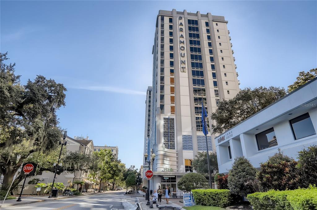 A tall, modern high-rise building stands next to a street with a stop sign — 415-3 E PINE STREET, ORLANDO, FL
