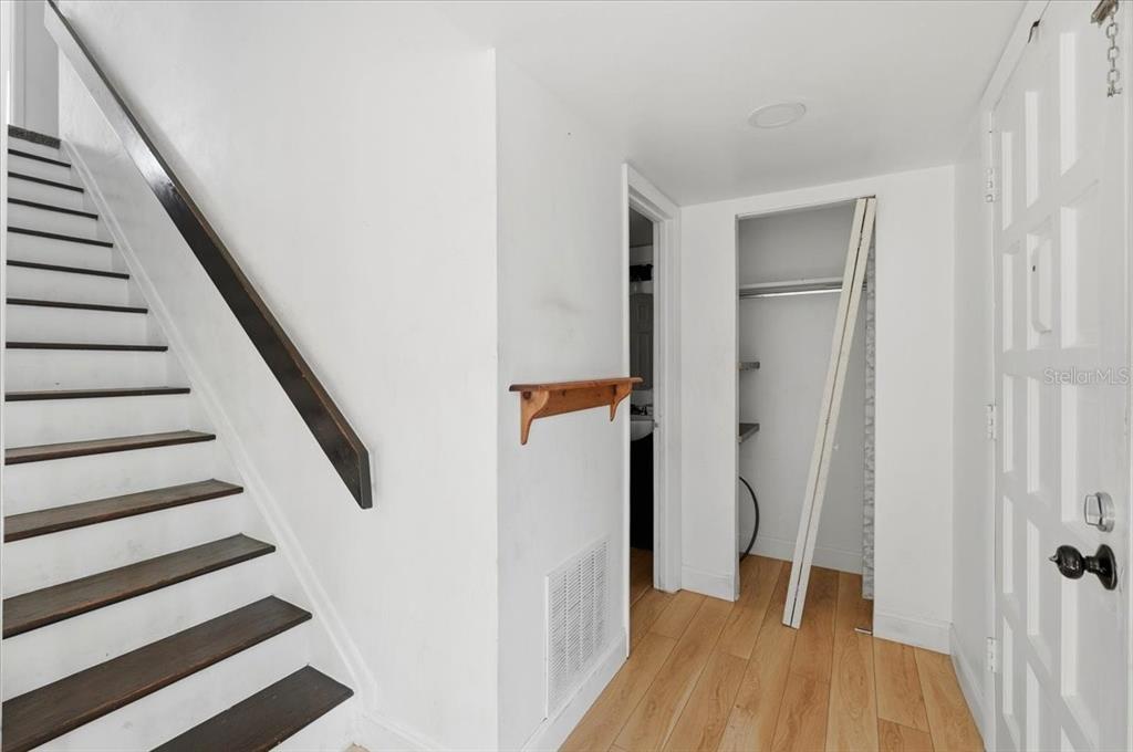 An interior view shows a staircase with dark treads, light wood flooring, and an open closet — 1836 N CRYSTAL LAKE DRIVE UNIT 70, LAKELAND, FL