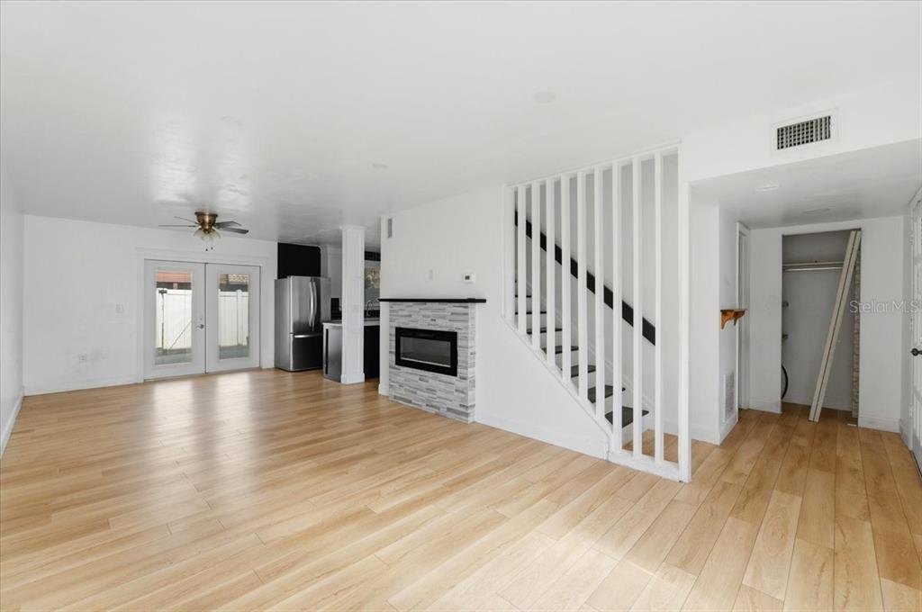 A living room features light wood flooring, a fireplace, and a staircase with white railings — 1836 N CRYSTAL LAKE DRIVE UNIT 70, LAKELAND, FL